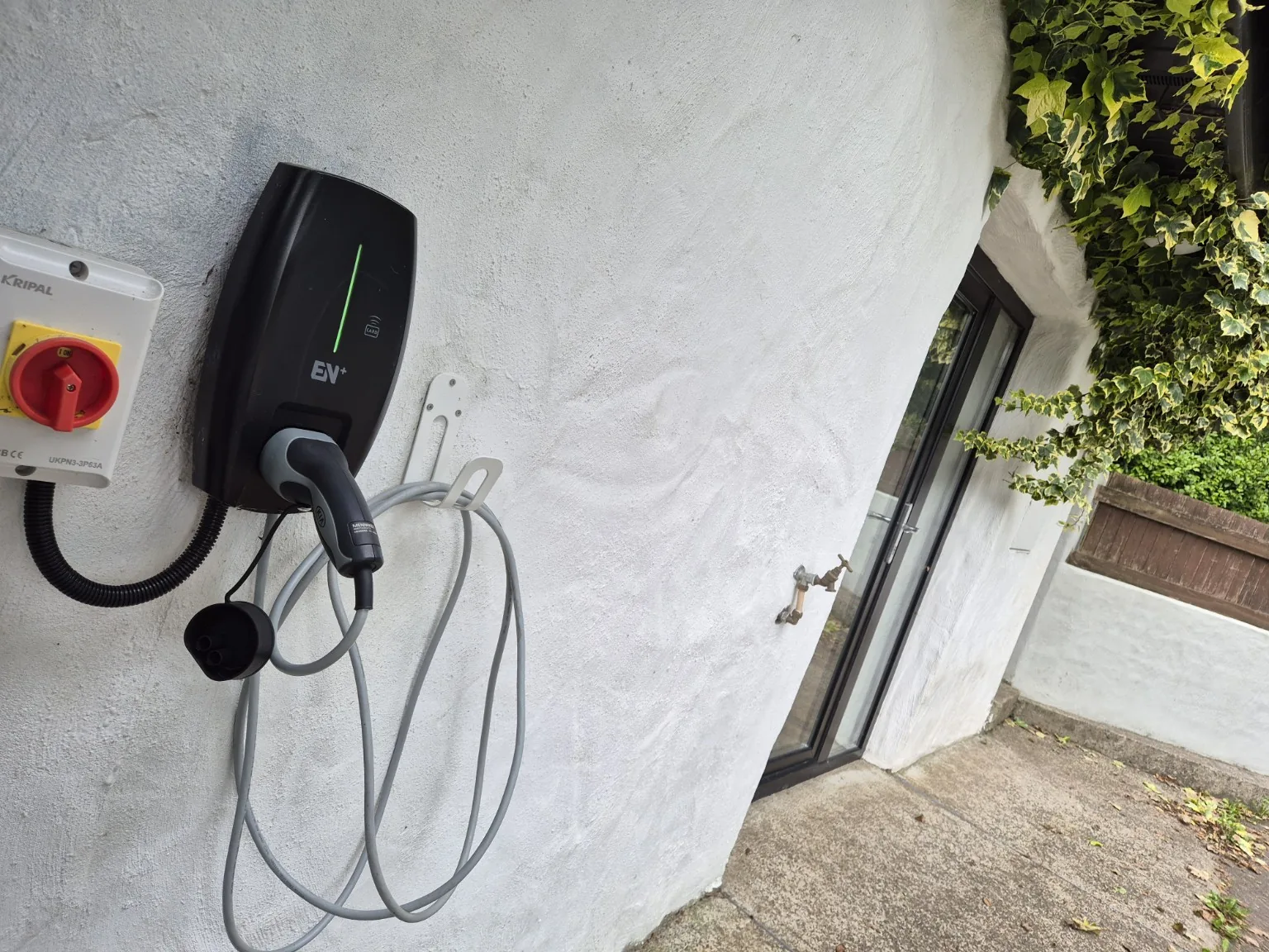 Close-up of a wall-mounted EV charger installed by Proxima Electrical and Security